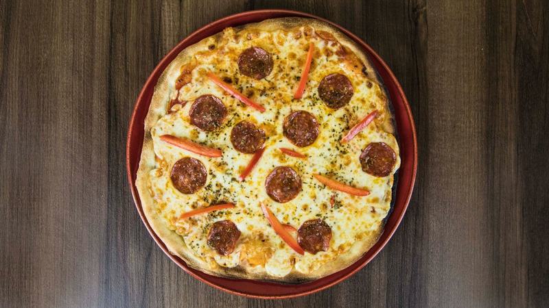 Pepperoni pizza fresh from the oven on a red platter